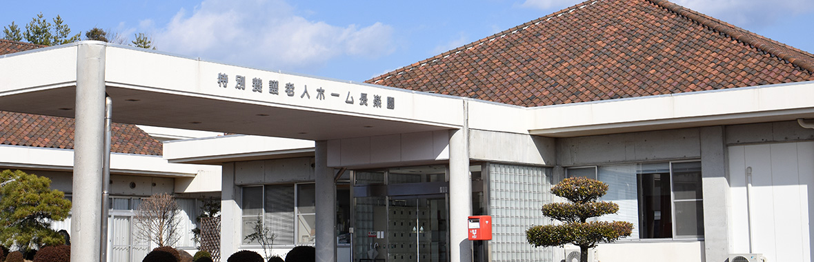 介護ホーム施設の建物外観。白と茶色の現代的な平屋建築。